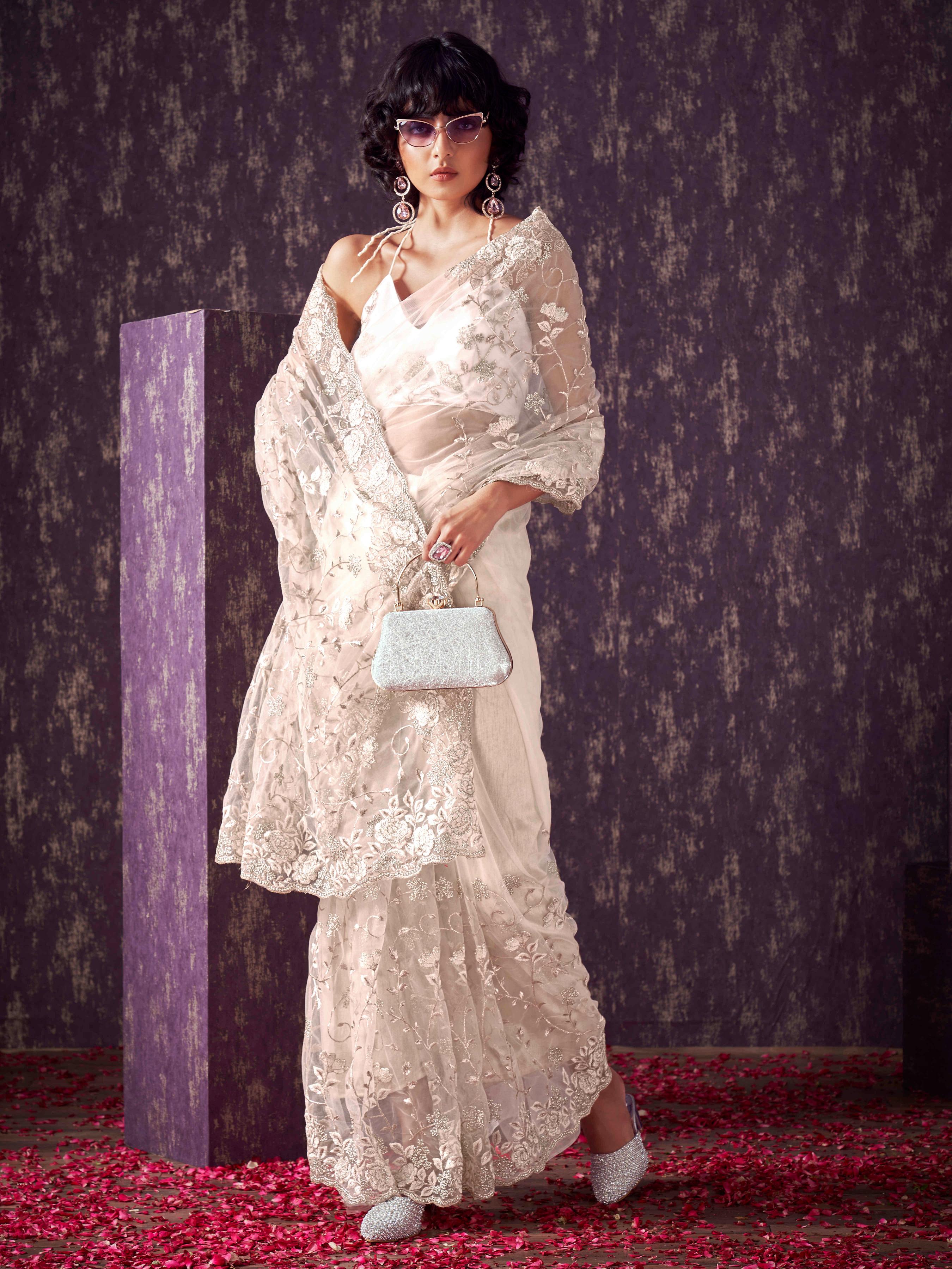 Off White colored embroidered net saree  with scalloped border