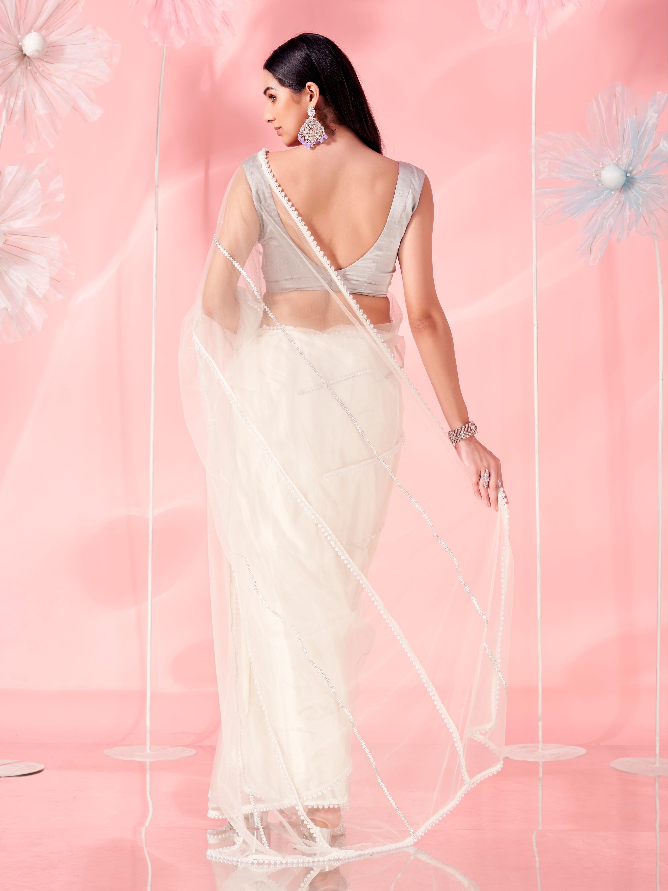 Off white colored designer net saree with faux beads and pearls stitched on pallu