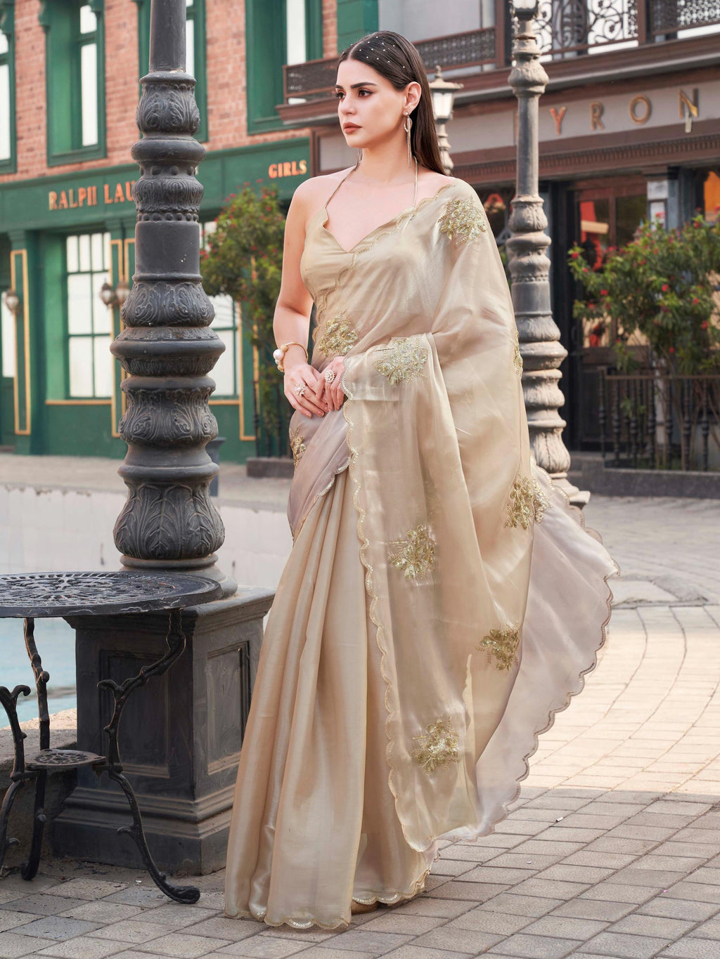 Beige colored burbery satin saree with sequinned embroidered butta on pallu and scalloped border