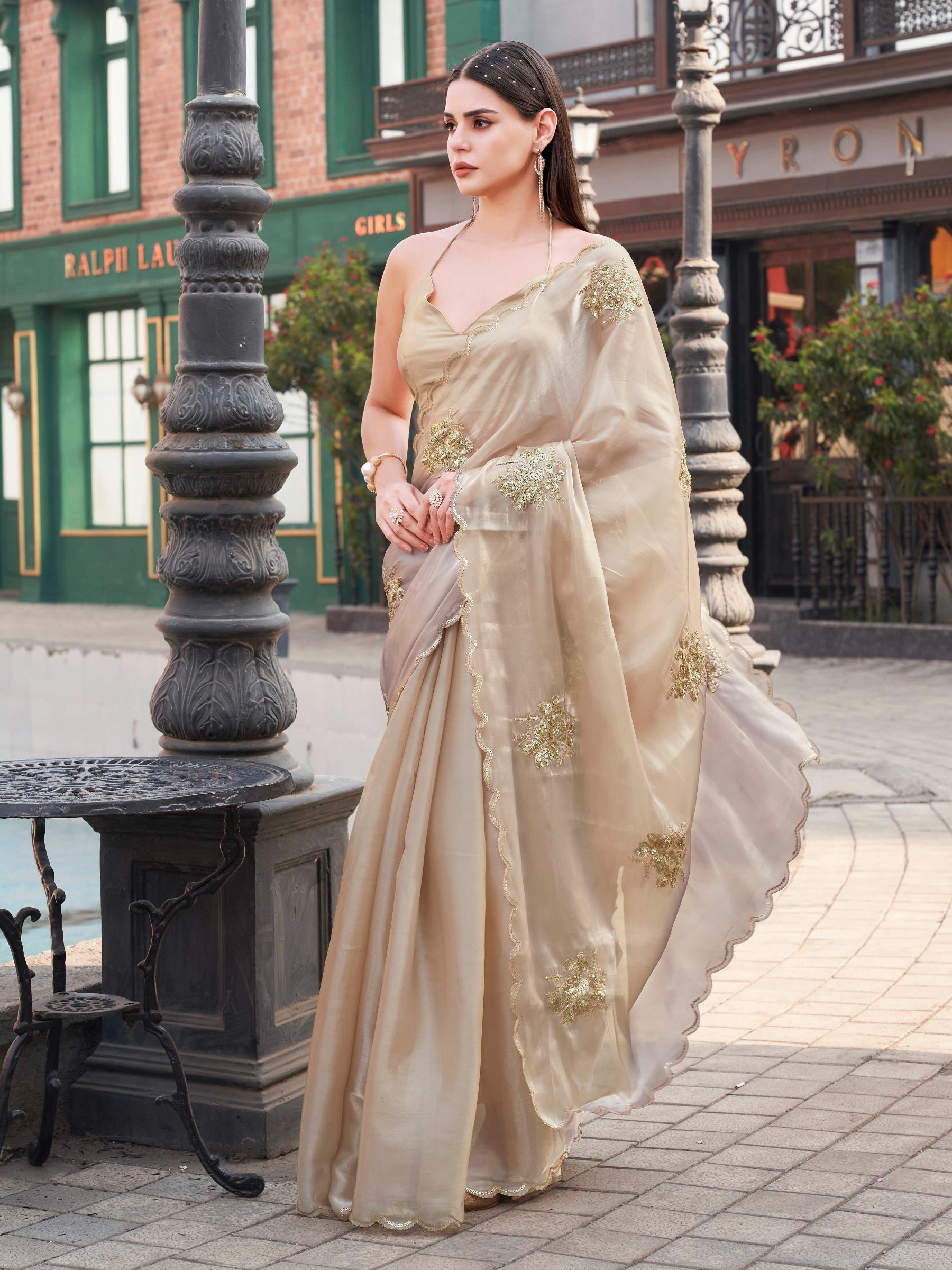 Beige colored burbery satin saree with sequinned embroidered butta on pallu and scalloped border