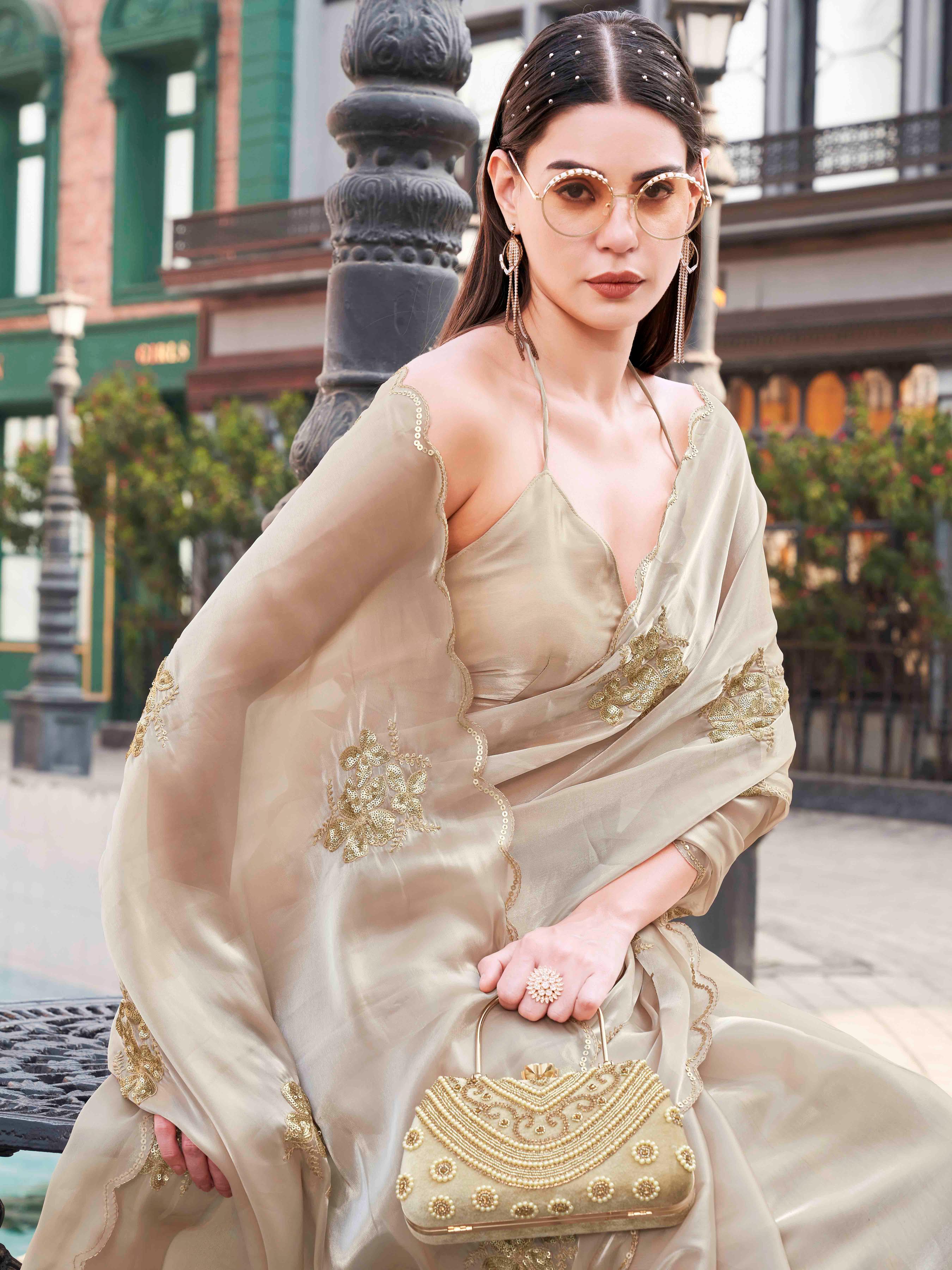 Beige colored burbery satin saree with sequinned embroidered butta on pallu and scalloped border