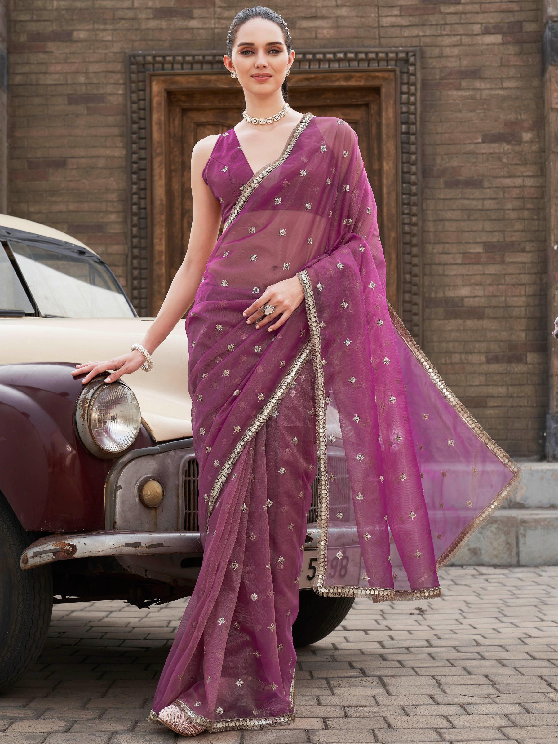 Pink colored shimmer net saree with sequinned butti and embroidered border