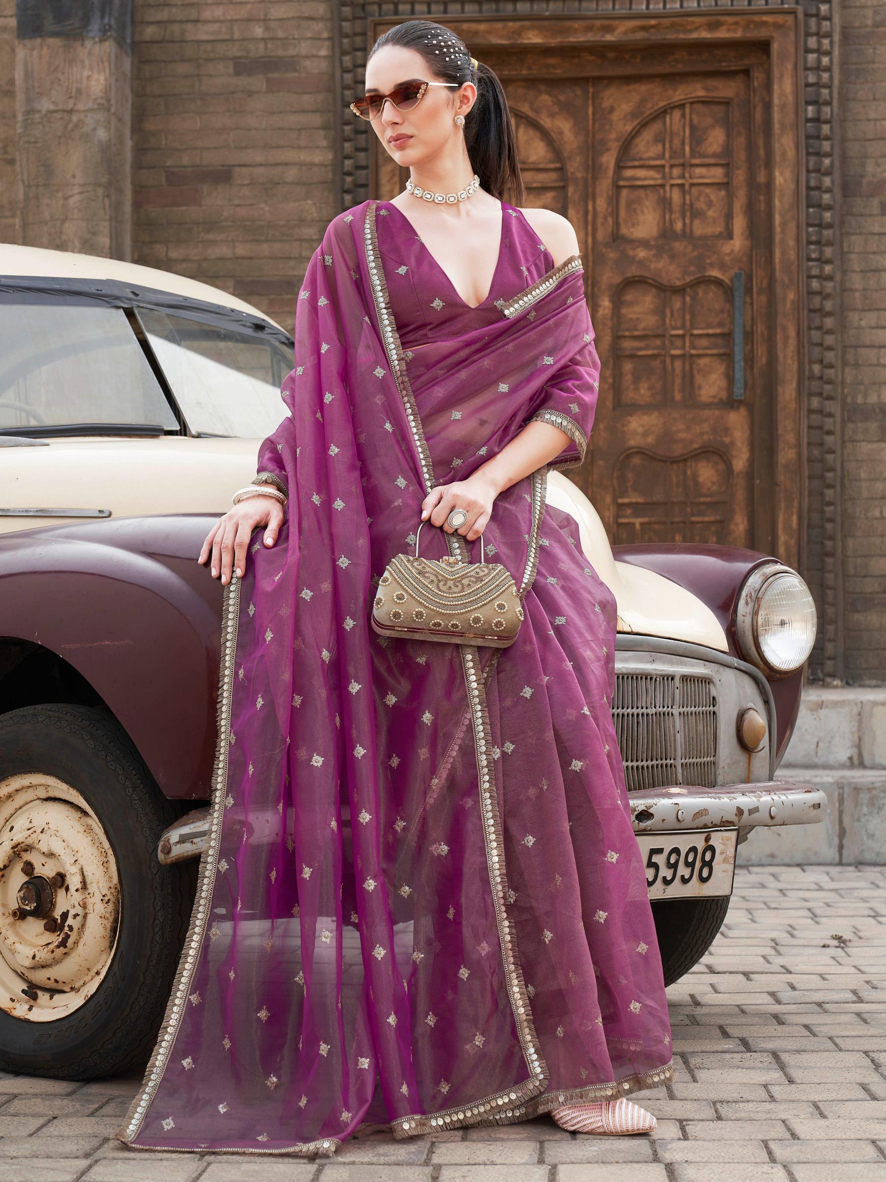 Pink colored shimmer net saree with sequinned butti and embroidered border