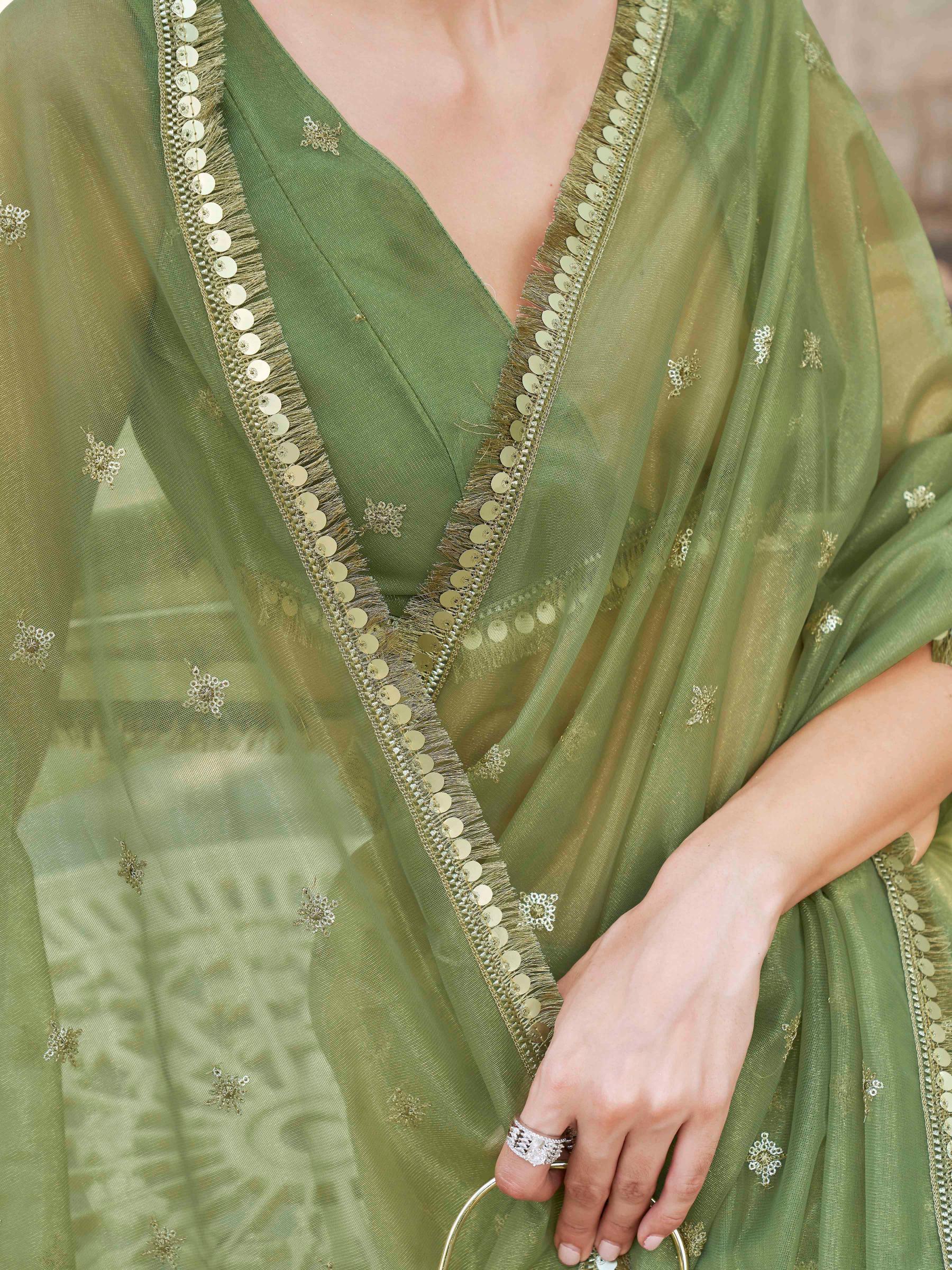 Green colored shimmer net saree with sequinned butti and embroidered border