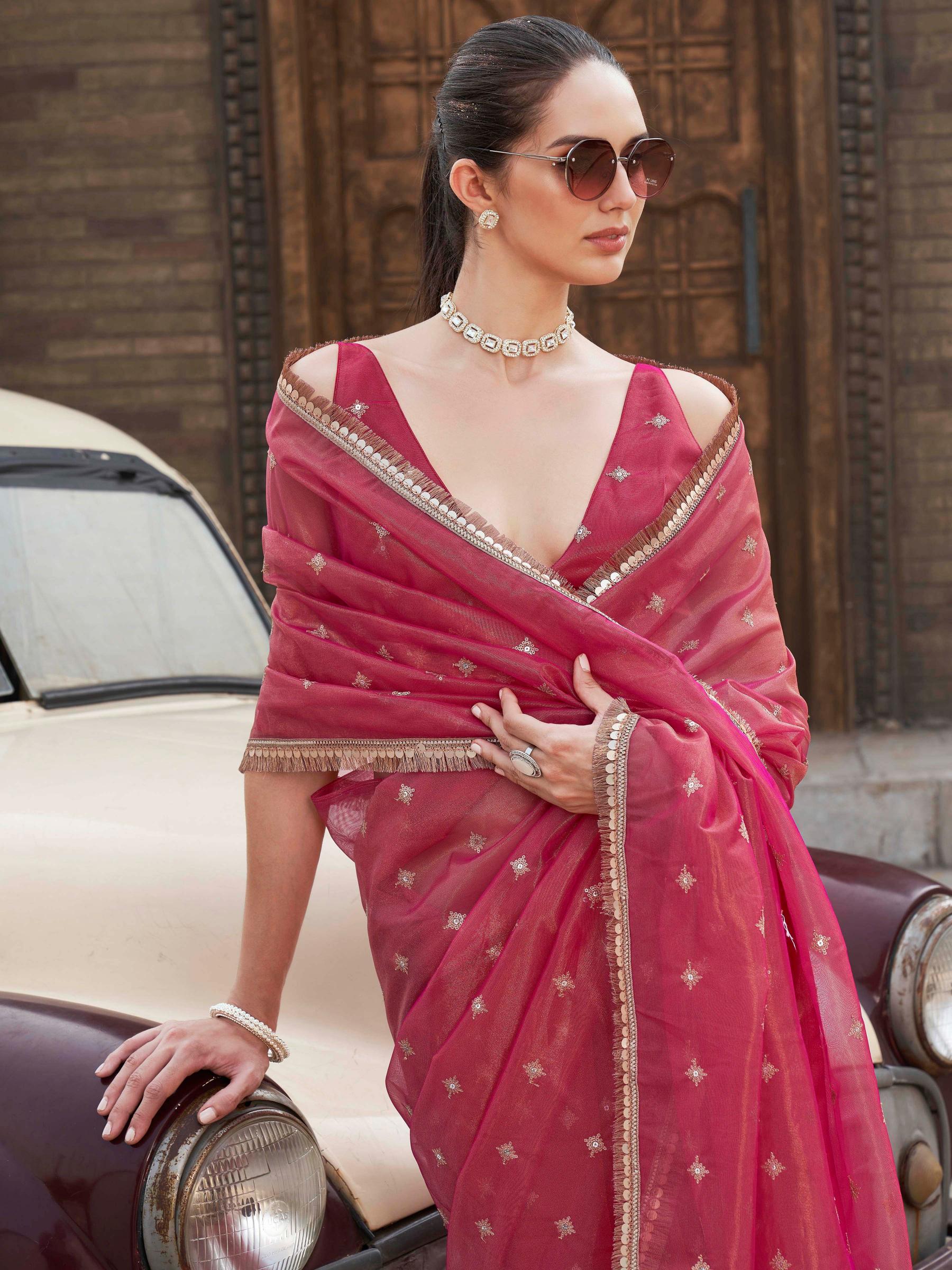 Pink colored shimmer net saree with sequinned butti and embroidered border
