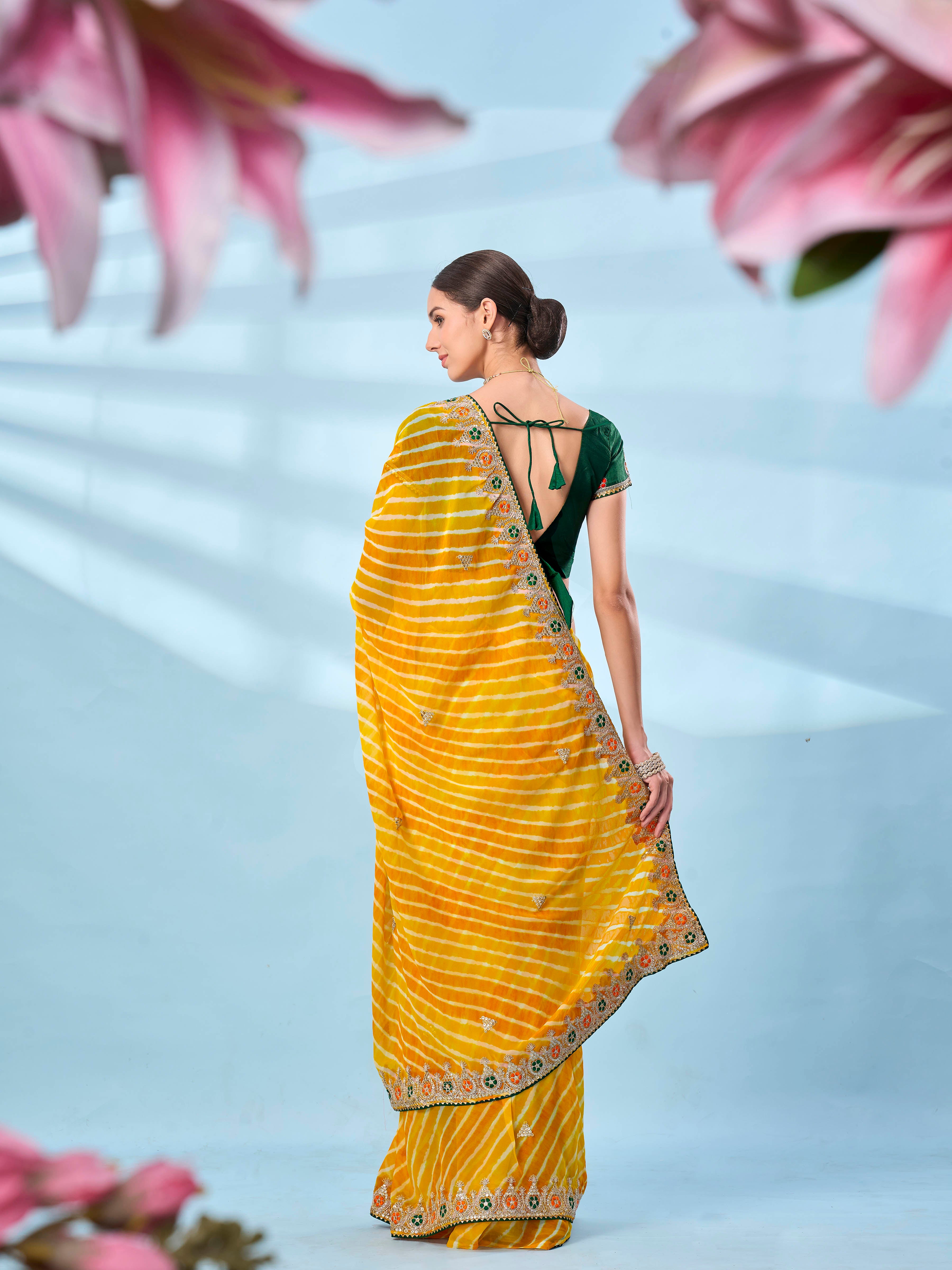 Yellow colored leheriya printed embroidered saree