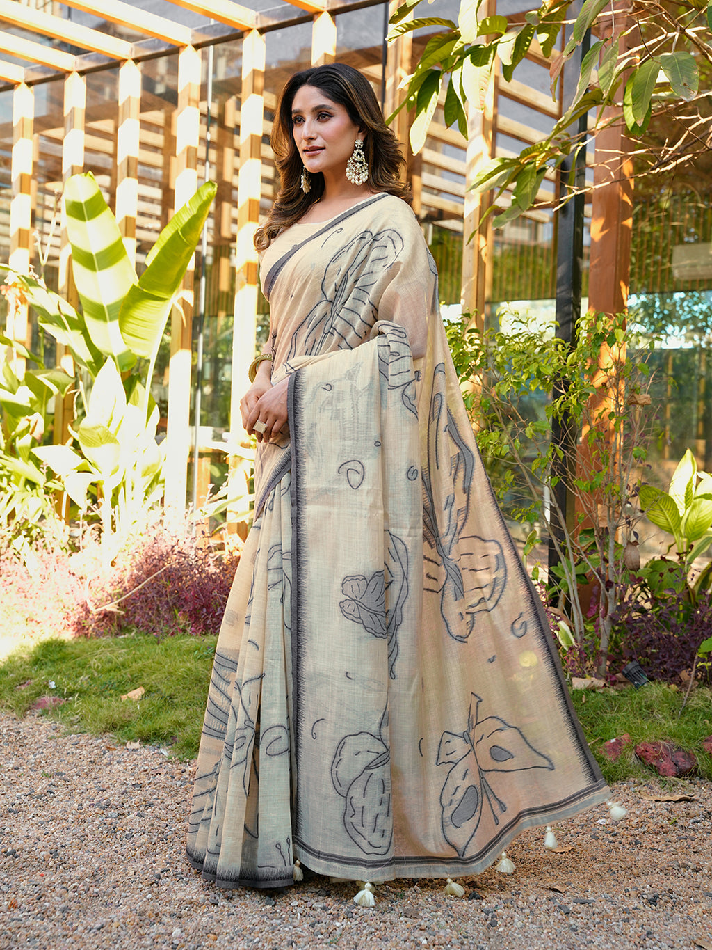 Beige colored muga cotton saree with tassles on pallu