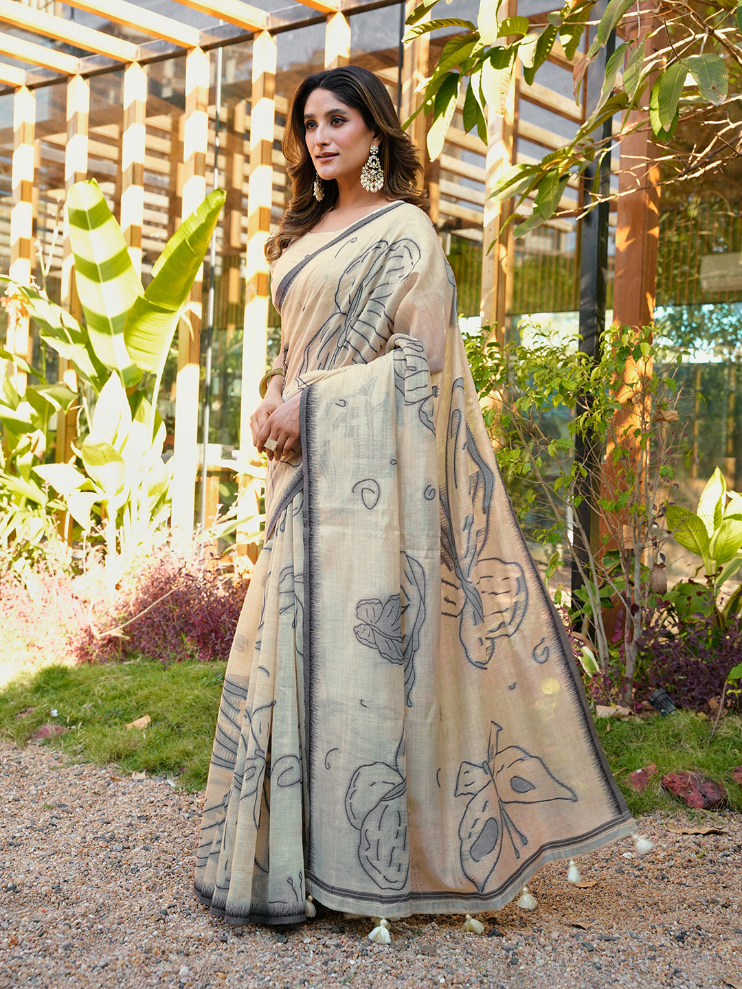Beige colored muga cotton saree with tassles on pallu