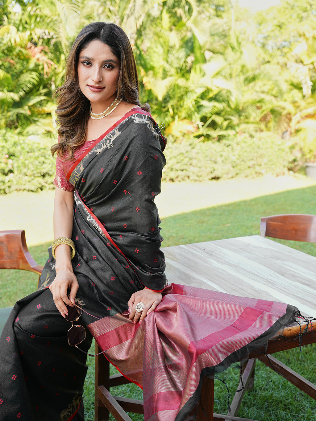 Black and red colored raw silk saree with tassles on pallu