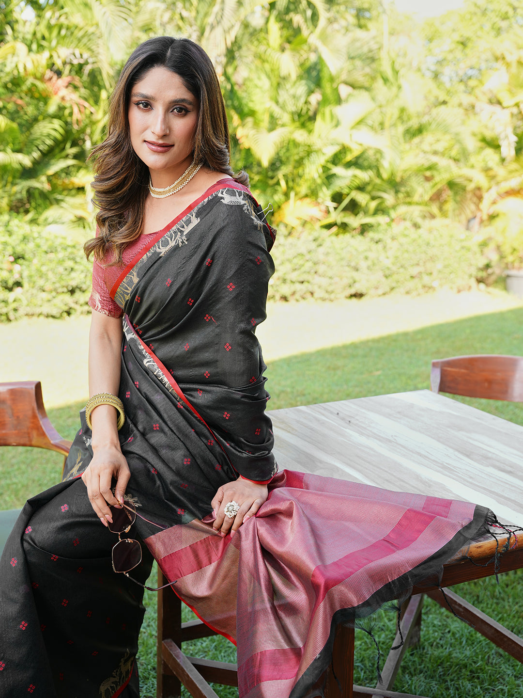 Black and red colored raw silk saree with tassles on pallu