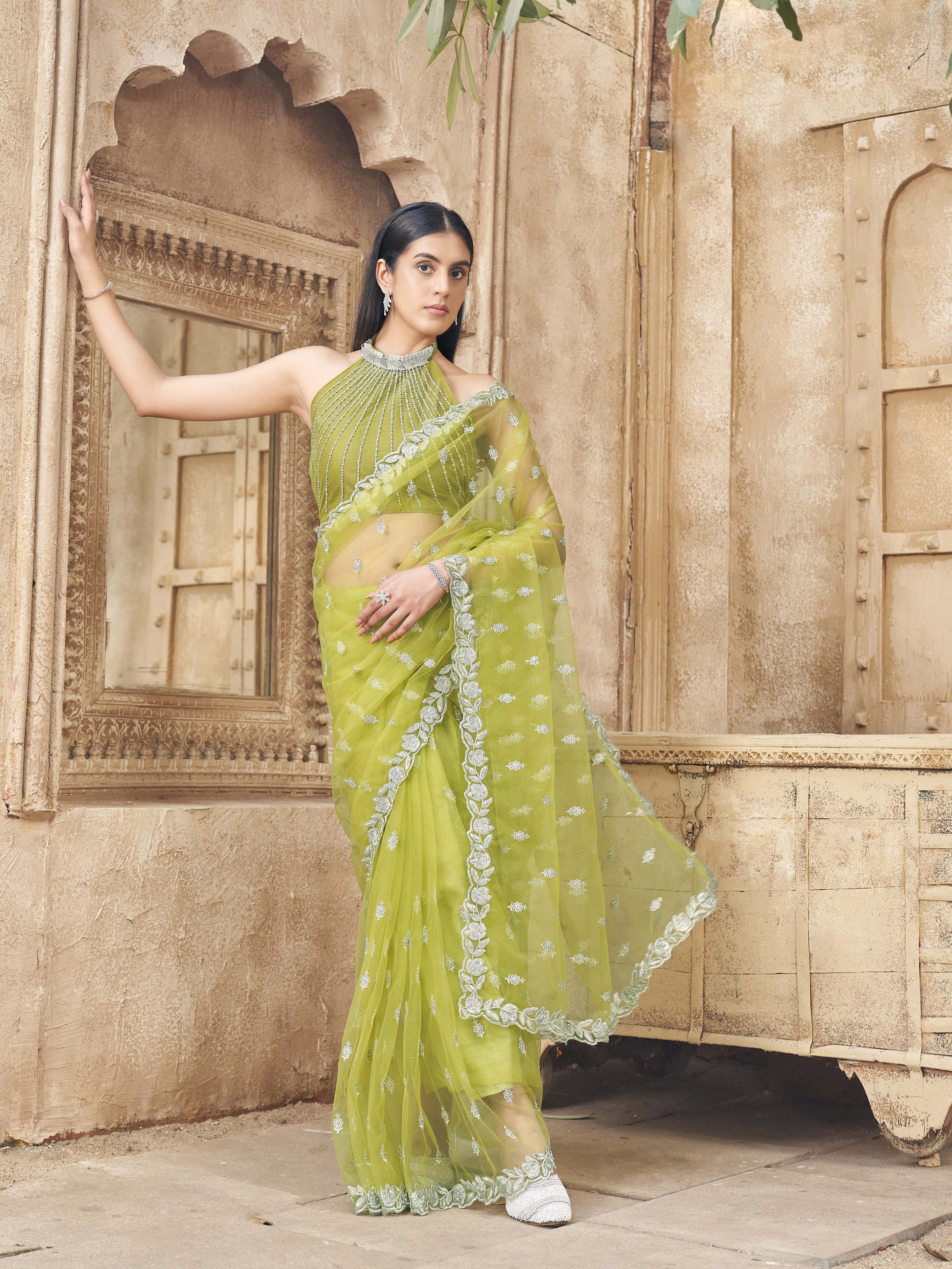 Neon green colored embroidered designer net saree with faux diamond