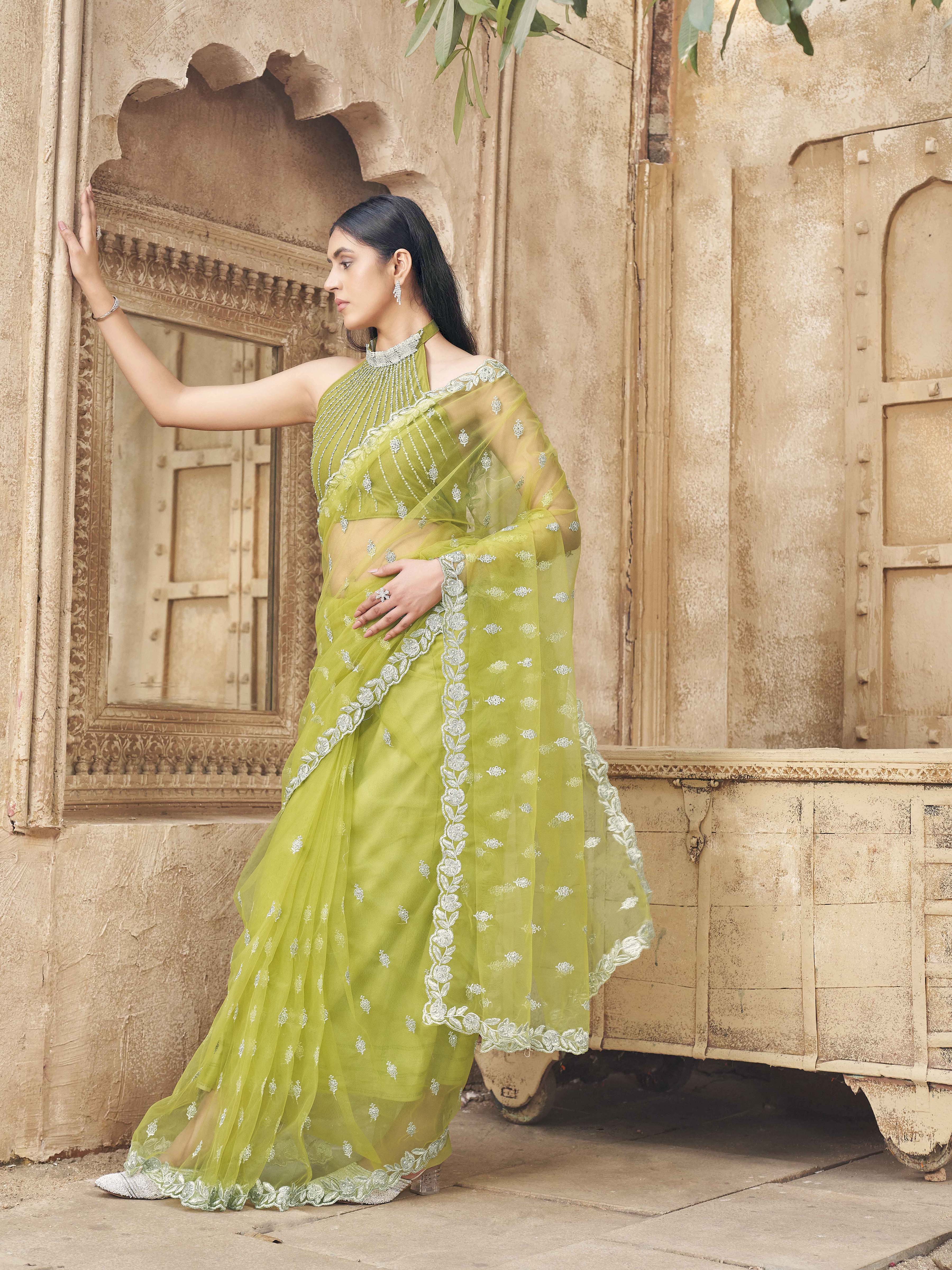 Neon green colored embroidered designer net saree with faux diamond