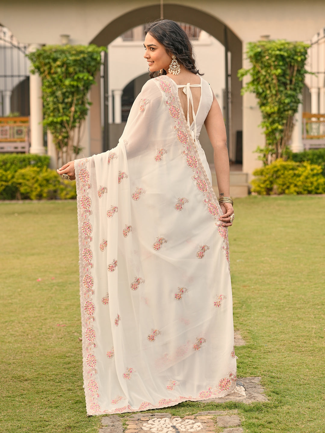 Off white colored shimmer georgette base embroidered saree