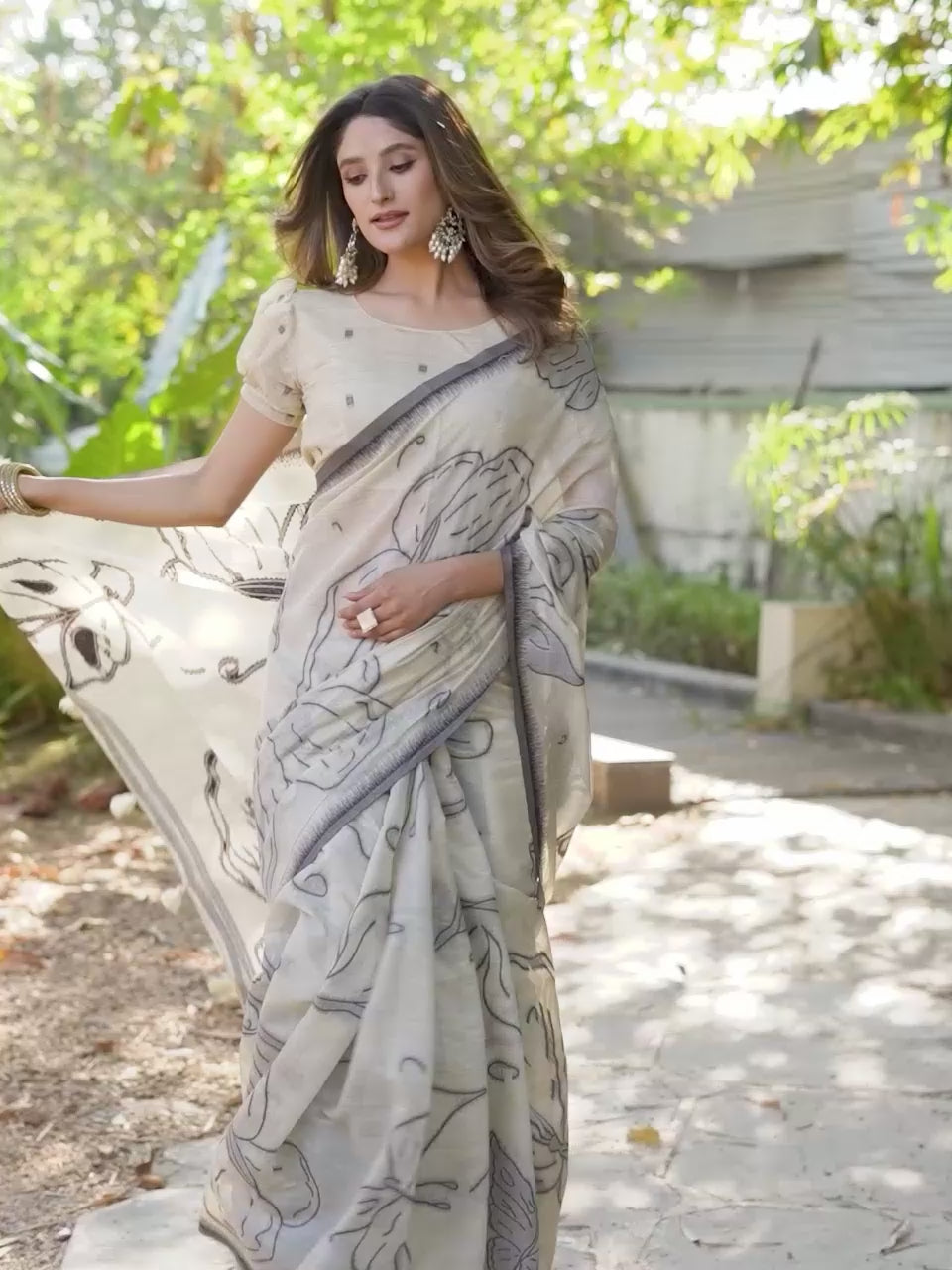 Beige colored muga cotton saree with tassles on pallu